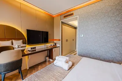 a hotel room with a bed and a desk at MQ Hotel Suites & SPA in Arnavutköy
