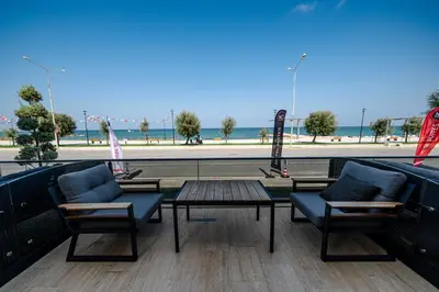a patio with two chairs and a table and a beach at MQ Hotel Suites & SPA in Arnavutköy