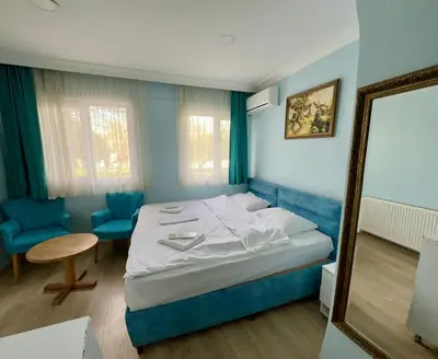 a bedroom with a bed and a table and a chair at AVRASYAQUEEN HOTEL in Istanbul