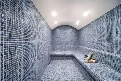 a bathroom with blue tiled walls and a tub at TRYP By Wyndham Istanbul Sisli Hotel in Istanbul