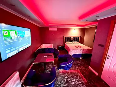 a room with two beds and a large screen at LEVENT PALACE REZİDANS in Istanbul