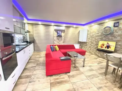 a living room with a red couch and a table at LEVENT PALACE REZİDANS in Istanbul