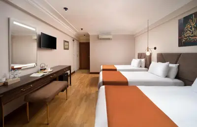 a hotel room with two beds and a desk at Recital Park Hotel in Istanbul