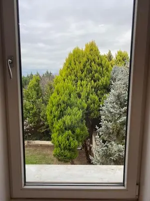 a window with a view of trees in a yard at Silivri Gazitepe'de 3 katlı, havuzlu lüks villa in Silivri