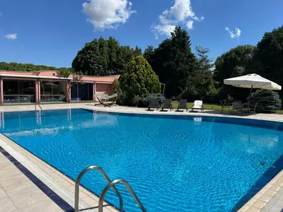 a large blue swimming pool with chairs and an umbrella at Silivri Gazitepe'de 3 katlı, havuzlu lüks villa in Silivri