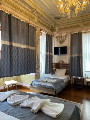 a bedroom with two beds and a chandelier at Valeria Antique 1892 in Istanbul