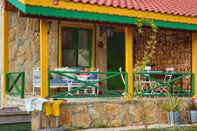a house with a table and chairs on the porch at Dachas Cove Hotel in Agva
