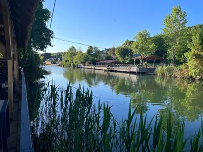 a river with buildings and trees on the side at Dachas Cove Hotel in Agva