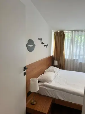 a bedroom with a bed with white sheets and a lamp at City Aparts Nisantasi in Istanbul