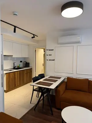 a kitchen and a living room with a table and a couch at City Aparts Nisantasi in Istanbul