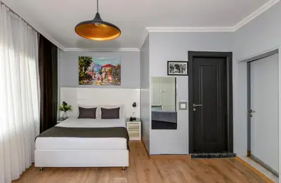 a bedroom with a white bed and a black door at Lavanta Hotel in Istanbul
