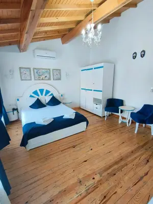 a bedroom with a bed and a wooden floor at MAVİ PALAS HOTEL in Buyukada