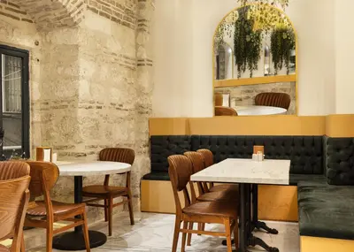 a restaurant with two tables and chairs and a mirror at Pera Rasso Hotel in Istanbul