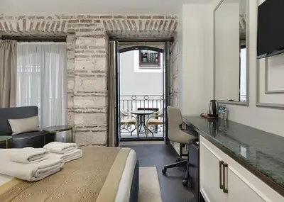 a hotel room with a bed and a desk and a table at Pera Rasso Hotel in Istanbul
