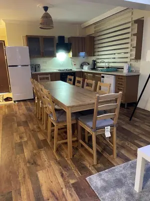 a kitchen with a large wooden table and chairs at Sultan Villa, Merkez Mahallesi Dogu Sirti Caddesi Sultan Sitesi H-2 in Kadıköy