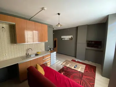 a living room with a red couch and a kitchen at 216 Hill Suites in Istanbul