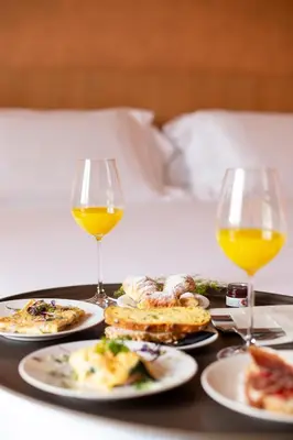 a tray with plates of food and two glasses of wine at Princely Suites Nişantaşı in Istanbul
