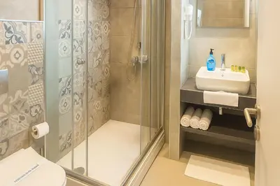 a bathroom with a shower and a sink at Homey AirPort Hotel in Arnavutköy