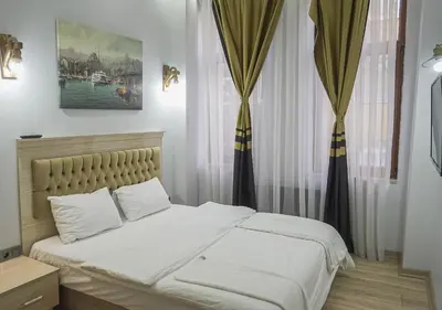 a bedroom with a bed with white sheets and curtains at Mar Suite in Istanbul