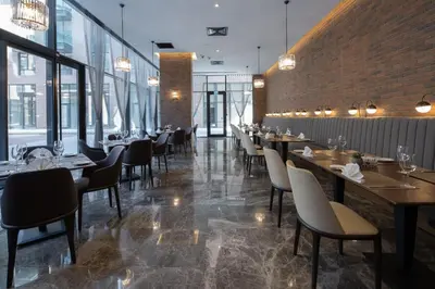 a restaurant with tables and chairs and a brick wall at Dedeman Kartepe Kocaeli in Kocaeli