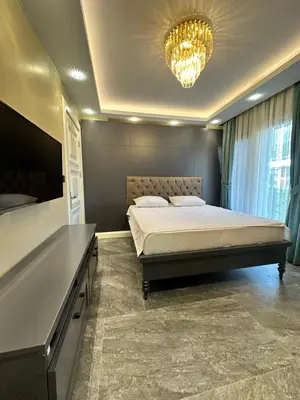a bedroom with a large bed and a chandelier at SAPANCA ALHARRAN VILLA in Sapanca