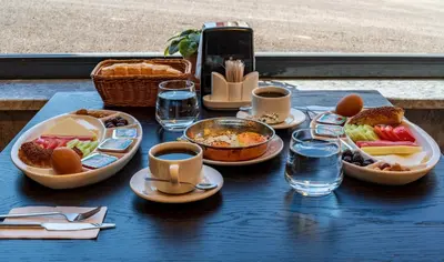 a blue table topped with plates of food and drinks at Görükle Alpaş Yaşam Hotel in Bursa