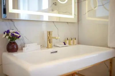 a bathroom sink with a gold faucet and a mirror at Loop Hotel Bosphorus İstanbul in Istanbul