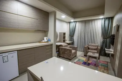 a kitchen with a counter and two chairs in a room at Sen Otel in Sakarya