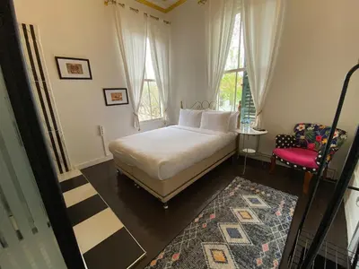 a bedroom with a white bed and a red chair at No16 Ada in Adalar