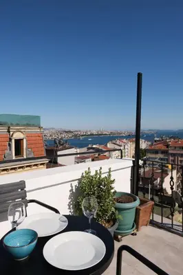 a table with two wine glasses on a balcony at Sunflower Apartments in Istanbul