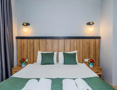 a bedroom with a large white bed with green accents at La Pera Suites Hotel in Istanbul