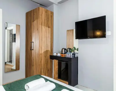 a room with a bed and a tv on a wall at La Pera Suites Hotel in Istanbul