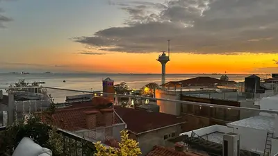 a view of a city with a lighthouse at sunset at sahar sultan hotel in Istanbul