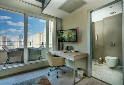 a room with a desk and a bathroom with a window at The Gate Ataşehir Finance Centre in Istanbul