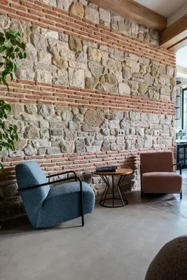 a brick wall with two chairs and a table at Istanbul Old City Colorful Houses Balat PETRION Hotel in Istanbul