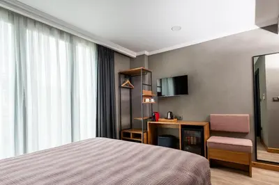 a hotel room with a bed and a desk and a mirror at Istanbul Old City Colorful Houses Balat PETRION Hotel in Istanbul