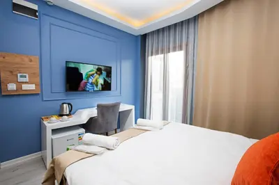 a bedroom with a white bed and a blue wall at Taksim Square Leon's Hotel in Istanbul