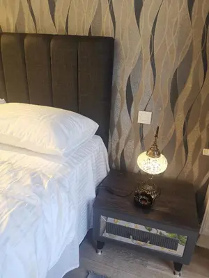 a bedroom with a bed and a table with a lamp at My G yoo Apartment #1 in Istanbul