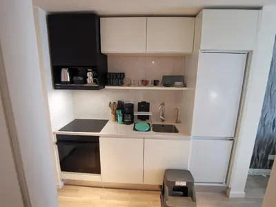 a small kitchen with white cabinets and a refrigerator at My G yoo Apartment #1 in Istanbul