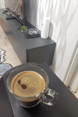 a cup of coffee sitting on a black table at My G yoo Apartment #1 in Istanbul