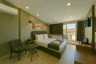 a hotel room with a bed and a chair and a window at Monezza Avcılar in Istanbul