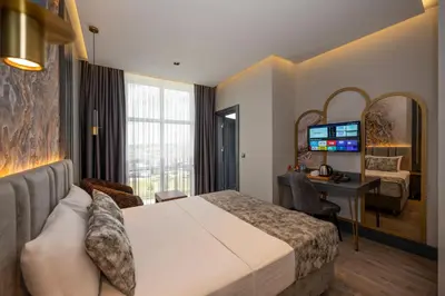 a hotel room with a bed and a desk with a computer at World Class Hotel - Istanbul Airport in Arnavutköy