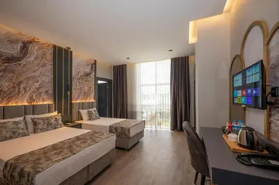 a hotel room with two beds and a desk at World Class Hotel - Istanbul Airport in Arnavutköy