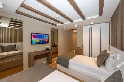 a bedroom with a bed and a tv on a wall at Hotel Grand İstanbul in Istanbul