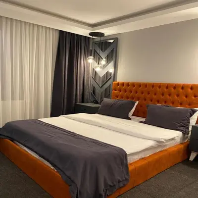 a bedroom with a large bed with an orange headboard at Valeron Suit Premium in Istanbul