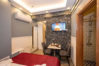 a bedroom with a table and a tv on a wall at Taksim Story Residence in Istanbul