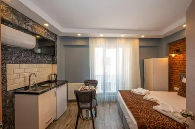 a room with a bed and a kitchen with a sink at Taksim Story Residence in Istanbul