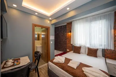 a bedroom with a bed and a table and a window at Taksim Story Residence in Istanbul