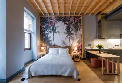 a bedroom with a large bed and a kitchen at Art Pera Suites in Istanbul