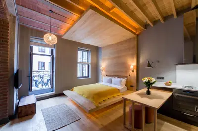 a bedroom with a bed and a table and a kitchen at Art Pera Suites in Istanbul